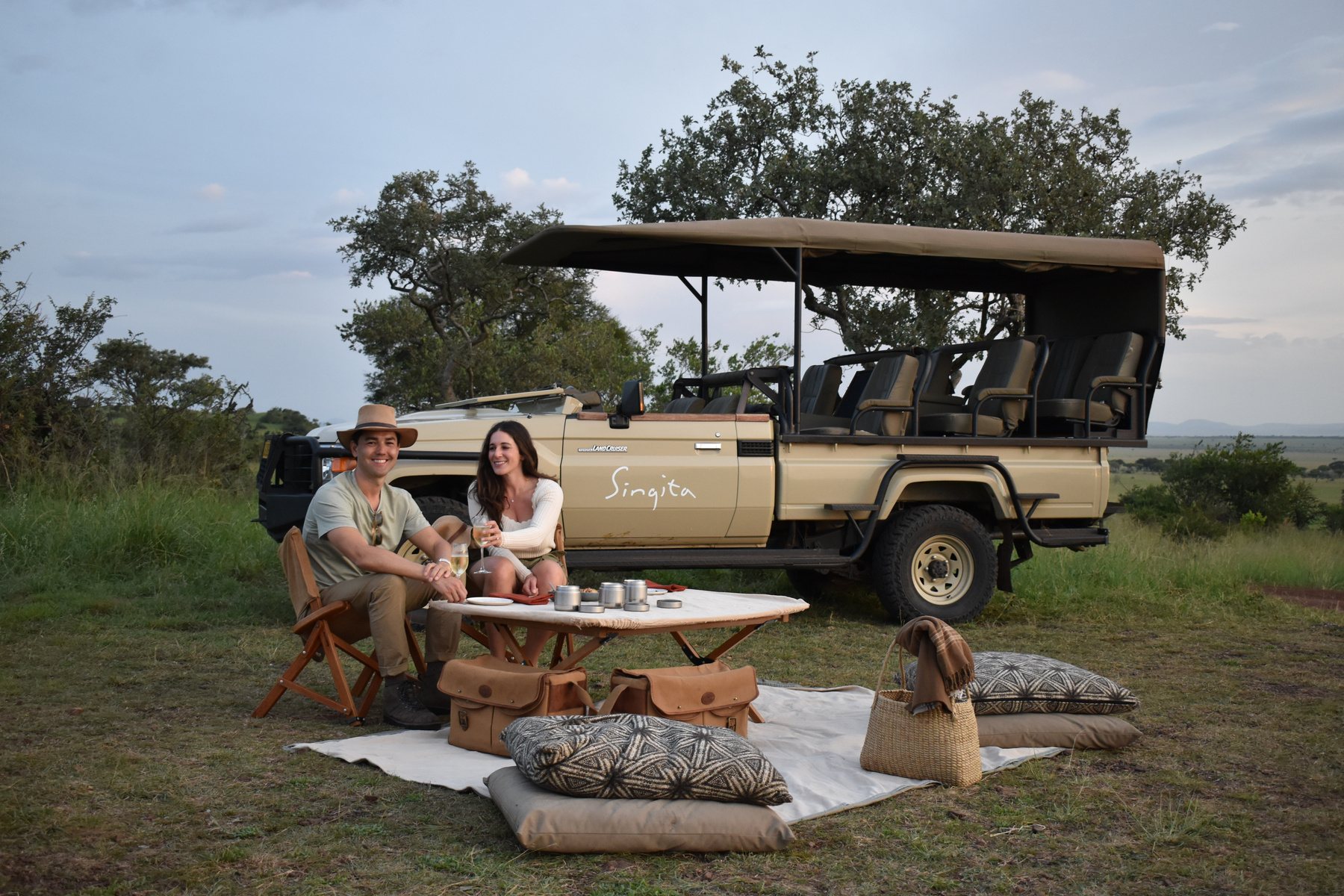 Julia and Jonah at a bush picnic beside the safari vehicle.